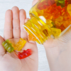 A hand holding gummy bear shaped vitamins